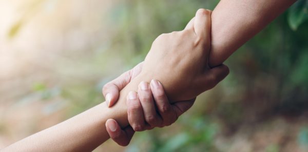 Two hands holding each other 's hand in a circle.