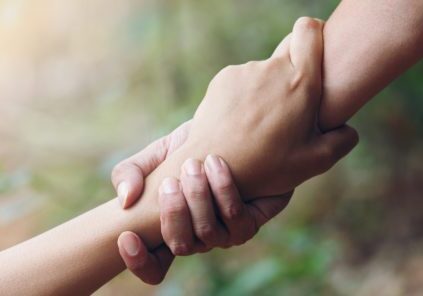 Two hands holding each other 's hand in a circle.